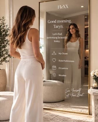A woman standing in front of the FleXX Mirror in her dressing room, the mirror greeting her by name.